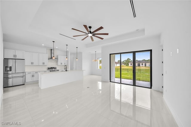 542 Raintree St E, Lehigh Acres, FL 33974 - unfurnished living room featuring a raised ceiling, ceiling fan, and light tile patterned floors
