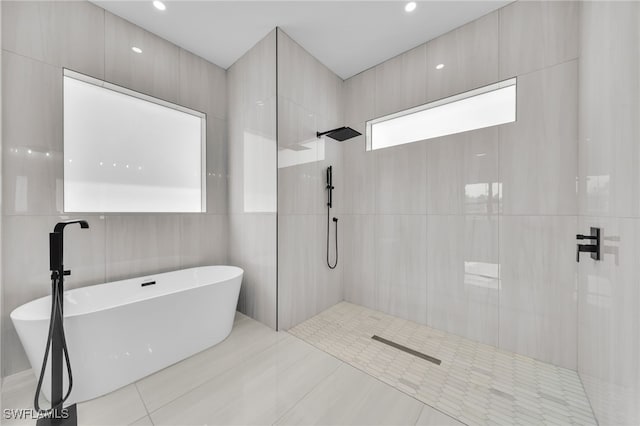 542 Raintree St E, Lehigh Acres, FL 33974 - full bath with a freestanding tub, a walk in shower, tile patterned flooring, tile walls, and recessed lighting