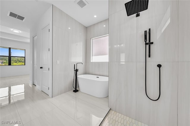 542 Raintree St E, Lehigh Acres, FL 33974 - full bathroom featuring a soaking tub, tile patterned flooring, a shower, and tile walls