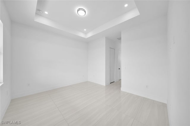 542 Raintree St E, Lehigh Acres, FL 33974 - unfurnished room with a raised ceiling, recessed lighting, and light tile patterned floors