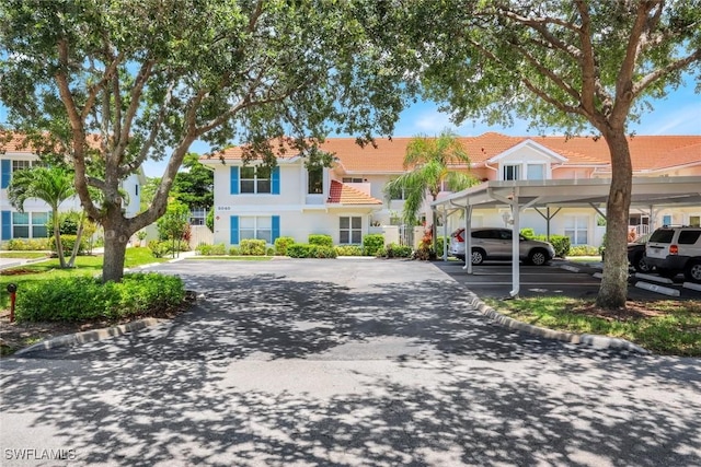 5040 Cedar Springs Dr Unit 201, Naples, FL 34110 - view of front of property featuring covered parking and a tiled roof