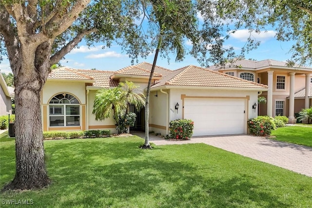 4333 Mistlethrush Ln, Naples, FL 34119 - mediterranean / spanish-style house with an attached garage, a tiled roof, a front yard, and driveway