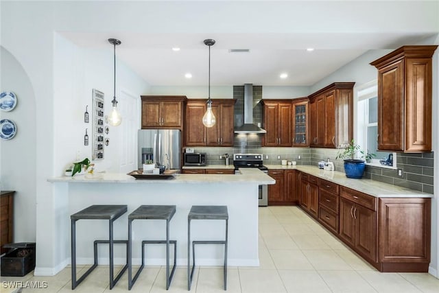 4333 Mistlethrush Ln, Naples, FL 34119 - kitchen featuring stainless steel appliances, wall chimney range hood, a peninsula, decorative backsplash, and recessed lighting