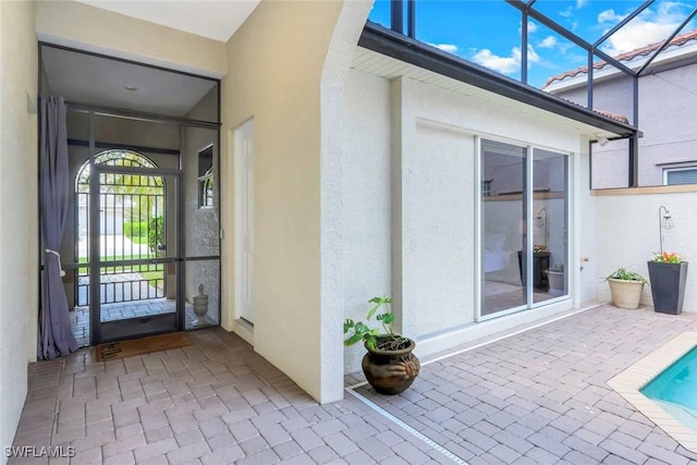 4333 Mistlethrush Ln, Naples, FL 34119 - doorway to property featuring stucco siding, a patio, and an outdoor pool