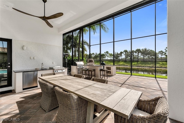 4406 Caldera Cir, Naples, FL 34119 - view of patio with an outdoor kitchen, a water view, ceiling fan, and outdoor dining area