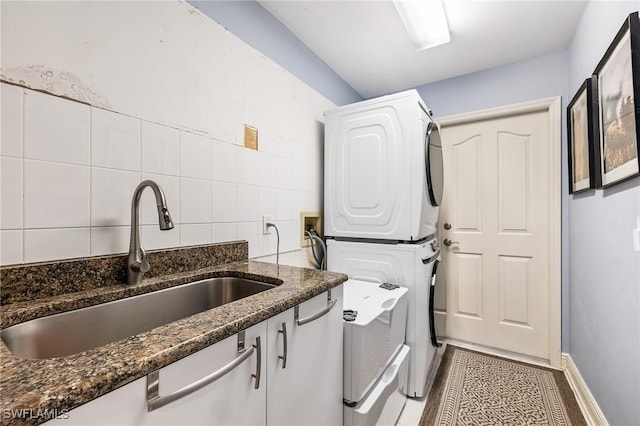 11840 Longshore Way W, Naples, FL 34119 - laundry room with stacked washer / dryer, cabinet space, and tile walls