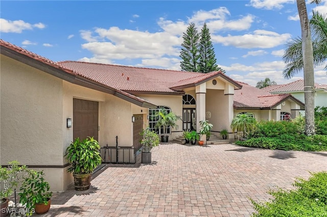11840 Longshore Way W, Naples, FL 34119 - view of front of home featuring stucco siding, a tile roof, and a patio area