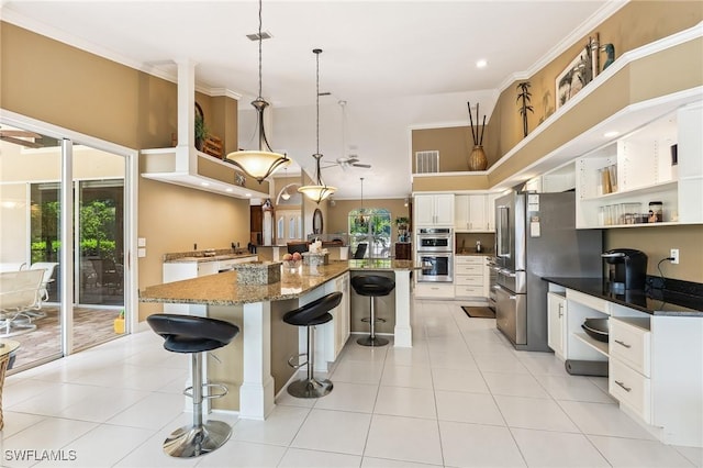11840 Longshore Way W, Naples, FL 34119 - kitchen featuring appliances with stainless steel finishes, a breakfast bar, open shelves, white cabinetry, and pendant lighting