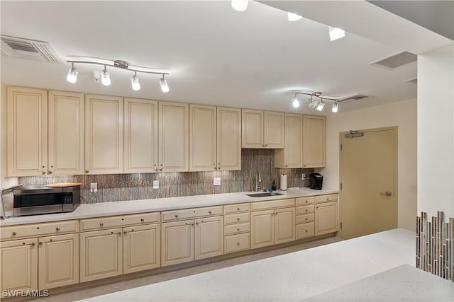 4137 Bay Beach Ln Unit 5P2, Fort Myers Beach, FL 33931 - kitchen featuring cream cabinets, track lighting, backsplash, and stainless steel microwave