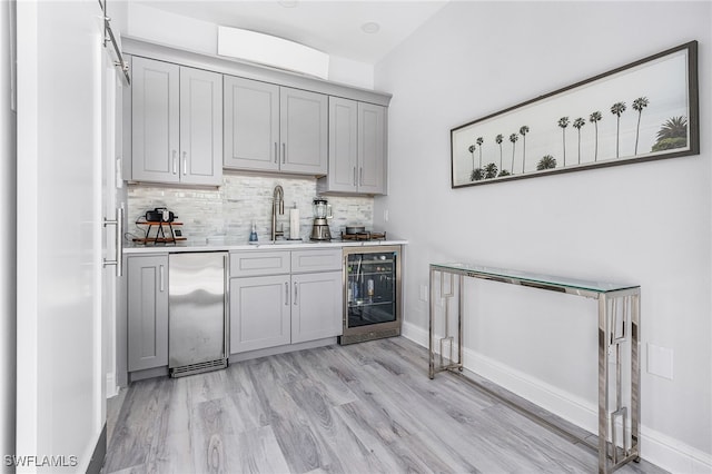 4137 Bay Beach Ln Unit 5P2, Fort Myers Beach, FL 33931 - bar area featuring beverage cooler, backsplash, high quality fridge, and light wood-style flooring