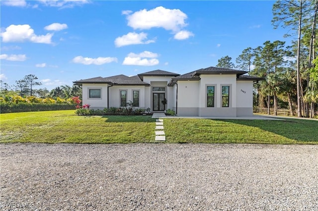 2642 10th Ave NE, Naples, FL 34120 - prairie-style home with stucco siding, a front lawn, and french doors