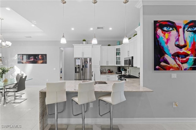 2642 10th Ave NE, Naples, FL 34120 - kitchen featuring stainless steel appliances, crown molding, a peninsula, glass insert cabinets, and decorative backsplash
