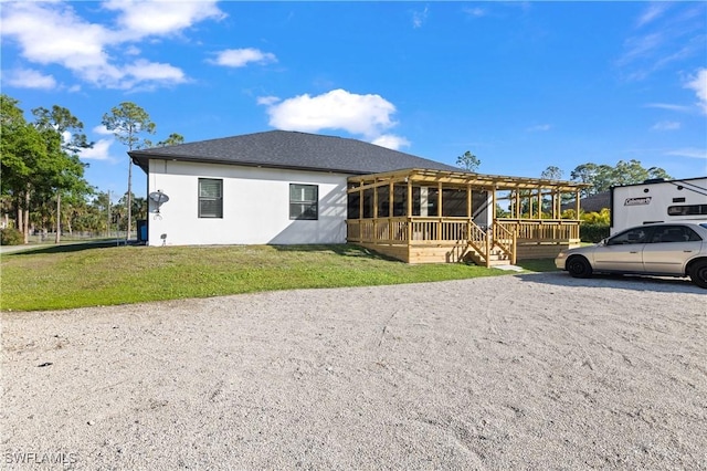 2642 10th Ave NE, Naples, FL 34120 - rear view of house with a sunroom, a lawn, stucco siding, and a deck
