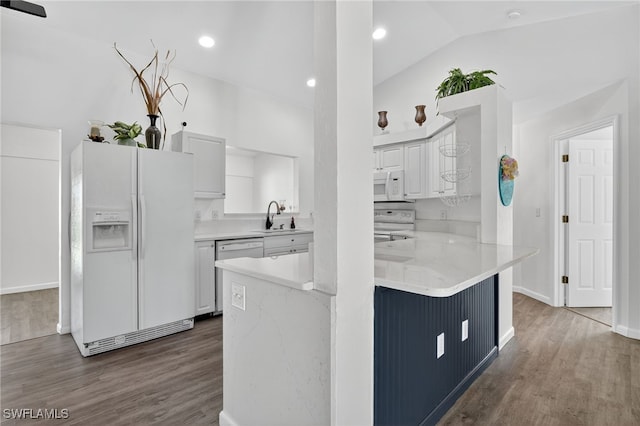 1905 SW 11th St, Cape Coral, FL 33991 - kitchen with white appliances, white cabinets, a peninsula, dark wood finished floors, and lofted ceiling