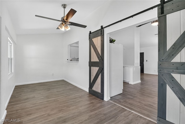 1905 SW 11th St, Cape Coral, FL 33991 - empty room with a barn door, wood finished floors, ceiling fan, and vaulted ceiling