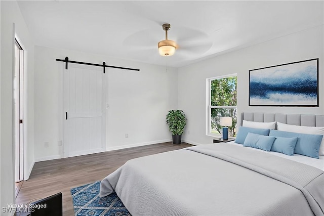 1905 SW 11th St, Cape Coral, FL 33991 - bedroom with wood finished floors, a barn door, and a ceiling fan