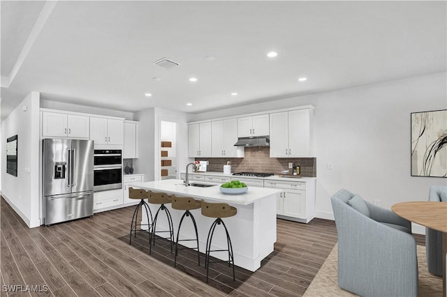 16272 Wax Myrtle St, Punta Gorda, FL 33982 - kitchen with appliances with stainless steel finishes, backsplash, a breakfast bar, recessed lighting, and white cabinetry