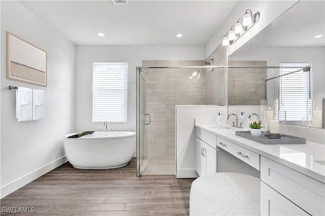 16272 Wax Myrtle St, Punta Gorda, FL 33982 - bathroom with double vanity, a soaking tub, wood tiled floors, a stall shower, and recessed lighting