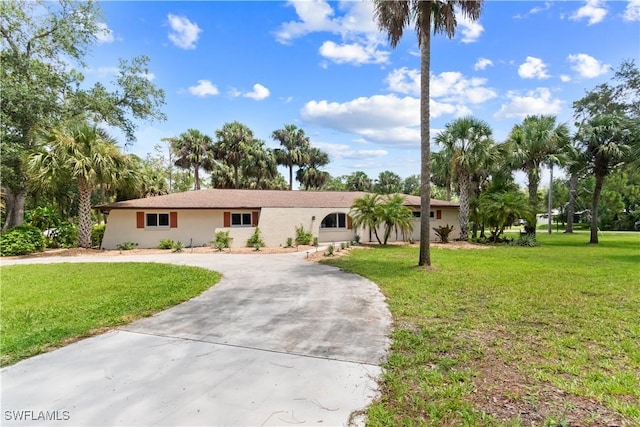 18381 Panther Trail Ln, North Fort Myers, FL 33917 - ranch-style home with curved driveway, a front lawn, and stucco siding