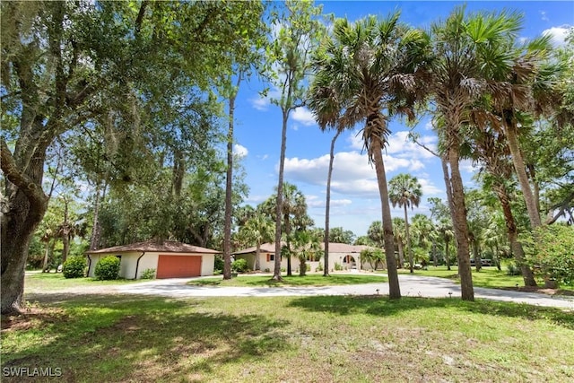 18381 Panther Trail Ln, North Fort Myers, FL 33917 - view of front of home with a garage, a front yard, driveway, and stucco siding