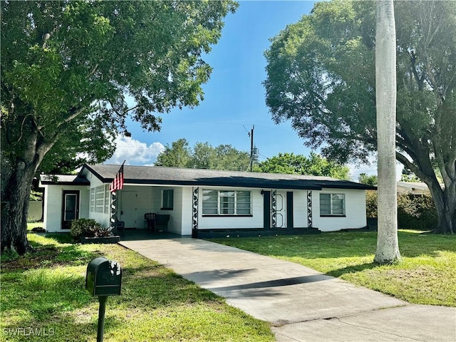 1427 Charles Rd, Fort Myers, FL 33919 - ranch-style home with concrete driveway, a carport, and a front yard