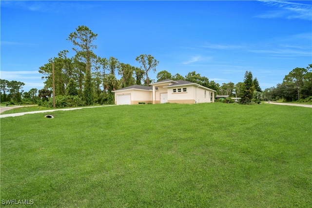 933 Anthony St E, Lehigh Acres, FL 33974 - view of grassy yard with an attached garage