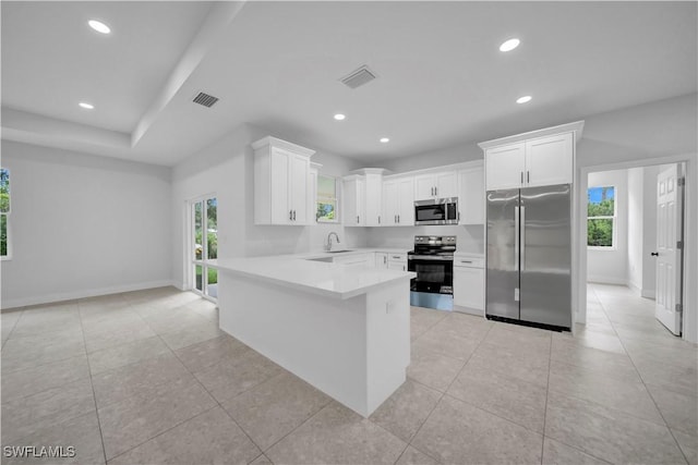 933 Anthony St E, Lehigh Acres, FL 33974 - kitchen with stainless steel appliances, plenty of natural light, a peninsula, white cabinetry, and recessed lighting