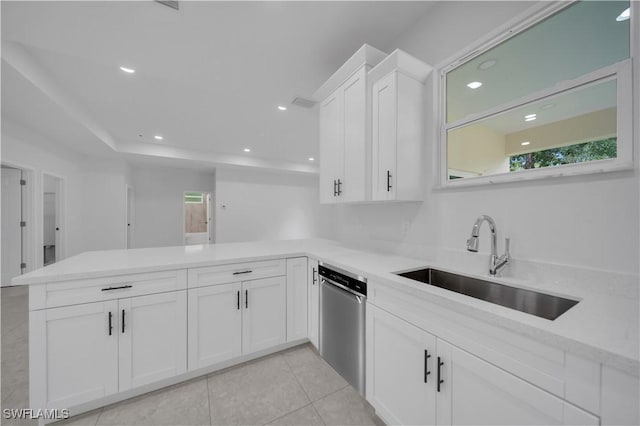 933 Anthony St E, Lehigh Acres, FL 33974 - kitchen with stainless steel dishwasher, a peninsula, white cabinets, light countertops, and healthy amount of natural light