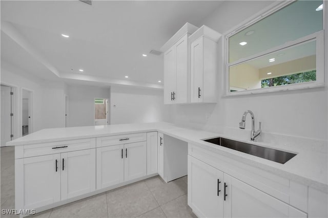 933 Anthony St E, Lehigh Acres, FL 33974 - kitchen with a peninsula, white cabinetry, light countertops, healthy amount of natural light, and recessed lighting