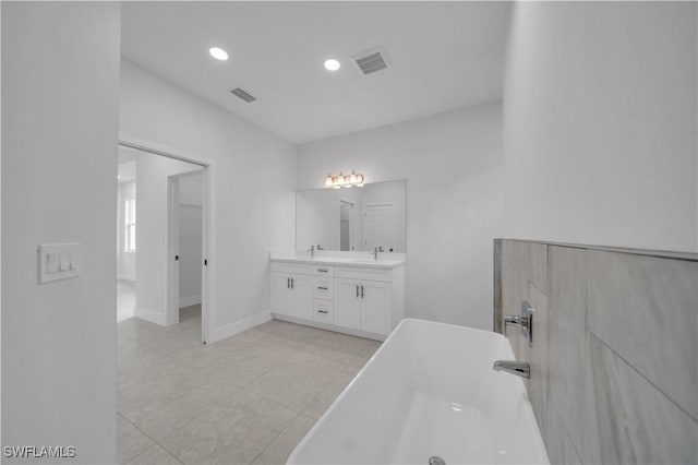 933 Anthony St E, Lehigh Acres, FL 33974 - full bathroom with a freestanding bath, double vanity, tile patterned flooring, and recessed lighting