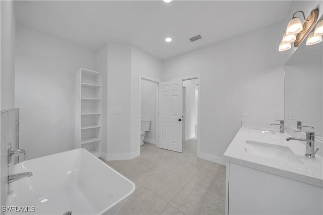 933 Anthony St E, Lehigh Acres, FL 33974 - bathroom with double vanity, a freestanding tub, tile patterned floors, and recessed lighting