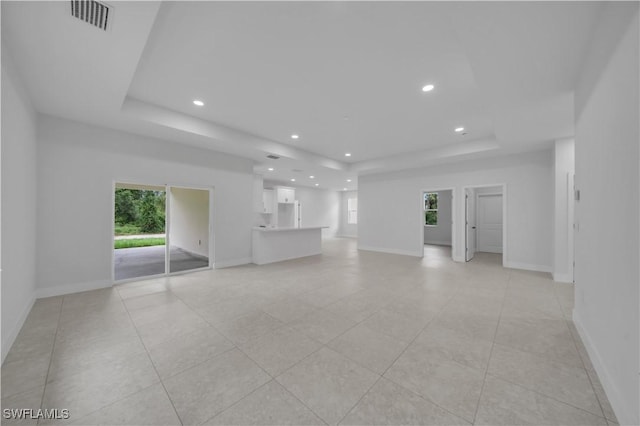 933 Anthony St E, Lehigh Acres, FL 33974 - unfurnished living room with a tray ceiling, recessed lighting, and light tile patterned flooring