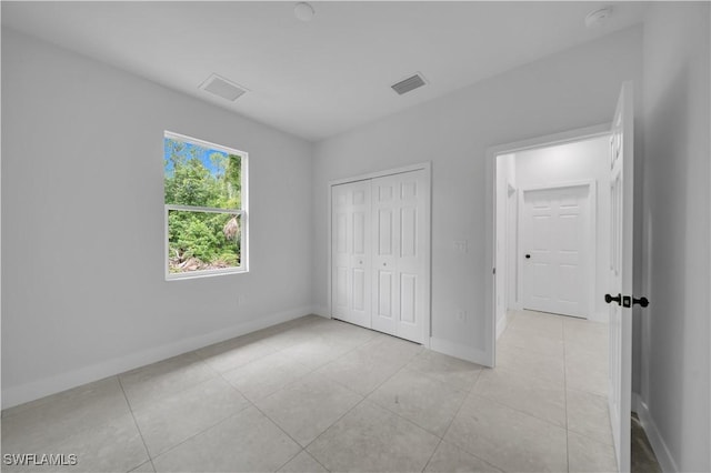 933 Anthony St E, Lehigh Acres, FL 33974 - unfurnished bedroom featuring light tile patterned floors and a closet