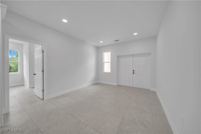 933 Anthony St E, Lehigh Acres, FL 33974 - empty room with healthy amount of natural light, recessed lighting, and light tile patterned flooring