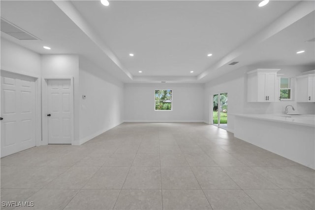 933 Anthony St E, Lehigh Acres, FL 33974 - unfurnished living room with light tile patterned floors, recessed lighting, and a tray ceiling