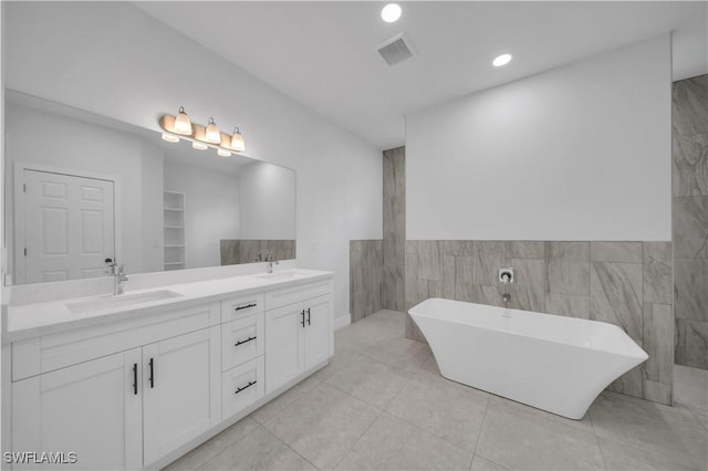 933 Anthony St E, Lehigh Acres, FL 33974 - full bathroom with a freestanding bath, double vanity, recessed lighting, and tile patterned flooring