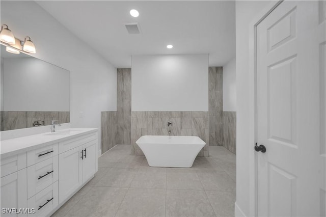 933 Anthony St E, Lehigh Acres, FL 33974 - full bathroom with vanity, a soaking tub, tile patterned flooring, tile walls, and recessed lighting