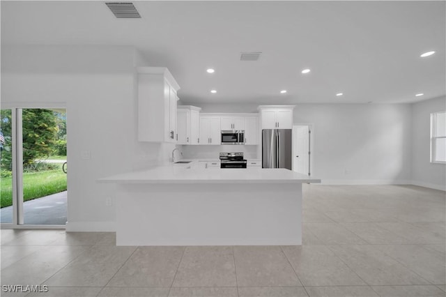 933 Anthony St E, Lehigh Acres, FL 33974 - kitchen with stainless steel appliances, healthy amount of natural light, light tile patterned flooring, and recessed lighting
