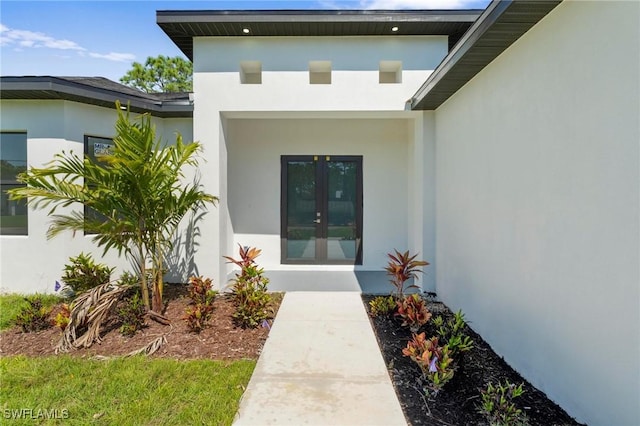 726 Cardinal St E, Lehigh Acres, FL 33974 - view of exterior entry with stucco siding and french doors