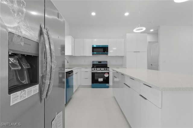 726 Cardinal St E, Lehigh Acres, FL 33974 - kitchen with stainless steel appliances, modern cabinets, white cabinets, a center island, and recessed lighting