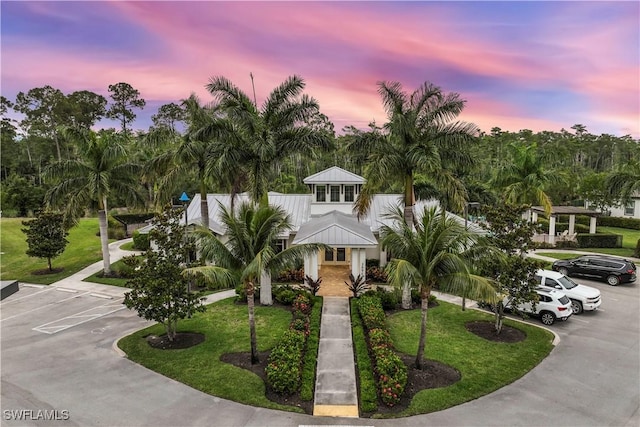 3829 Helmsman Dr, Naples, FL 34120 - view of front facade with uncovered parking, a front lawn, and a metal roof