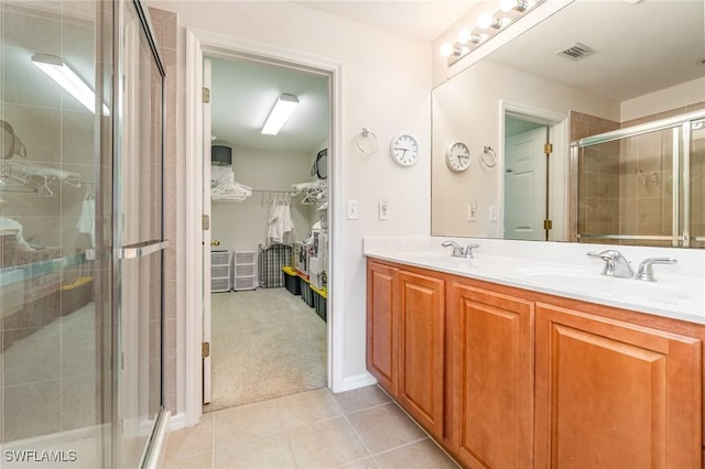 9322 Aegean Cir, Lehigh Acres, FL 33936 - full bathroom with a stall shower, double vanity, a walk in closet, and tile patterned flooring