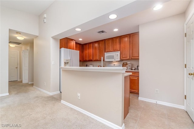 9322 Aegean Cir, Lehigh Acres, FL 33936 - kitchen with white appliances, light countertops, brown cabinets, and recessed lighting