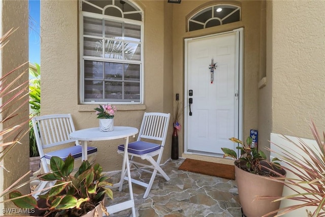 8644 Ibis Cove Cir, Naples, FL 34119 - view of exterior entry featuring stucco siding and covered porch