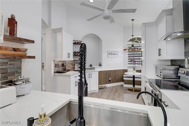 8644 Ibis Cove Cir, Naples, FL 34119 - kitchen featuring wall chimney exhaust hood, ceiling fan, tasteful backsplash, and white cabinetry