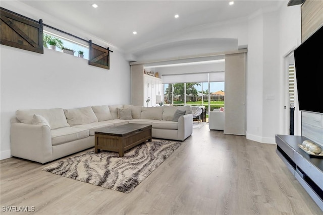 8644 Ibis Cove Cir, Naples, FL 34119 - living room with recessed lighting, wood finished floors, a barn door, and crown molding