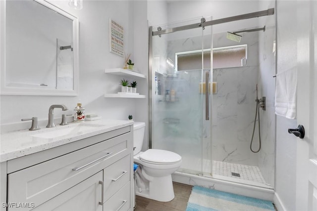 8644 Ibis Cove Cir, Naples, FL 34119 - bathroom featuring vanity, a marble finish shower, and wood finished floors