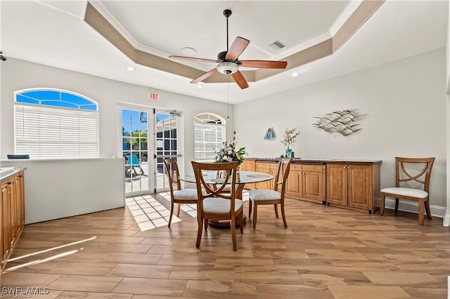 8644 Ibis Cove Cir, Naples, FL 34119 - dining area with a tray ceiling, light wood-style floors, recessed lighting, a ceiling fan, and crown molding