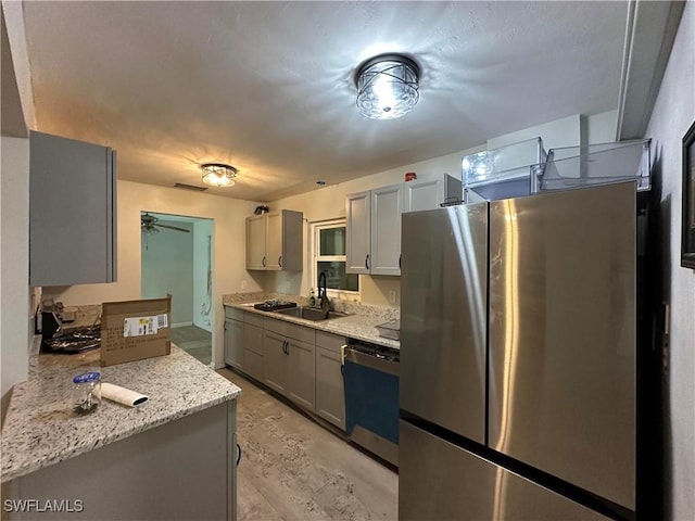 16940 Tarpon Way N, Fort Myers, FL 33917 - kitchen featuring gray cabinets, freestanding refrigerator, dishwasher, ceiling fan, and light stone countertops