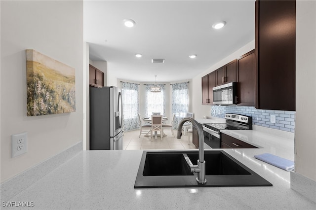 2245 Pigeon Plum Way N, Fort Myers, FL 33917 - kitchen with appliances with stainless steel finishes, dark brown cabinetry, decorative backsplash, decorative light fixtures, and recessed lighting
